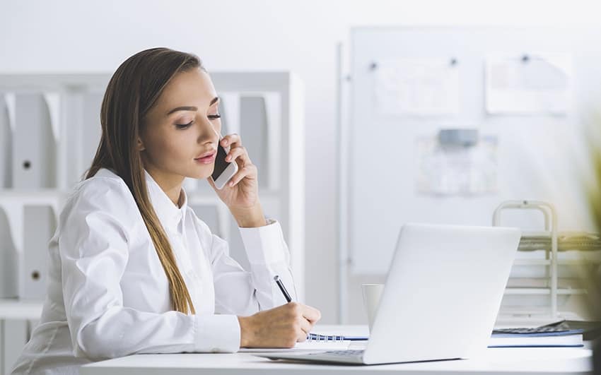 woman sitting at desk on the phone