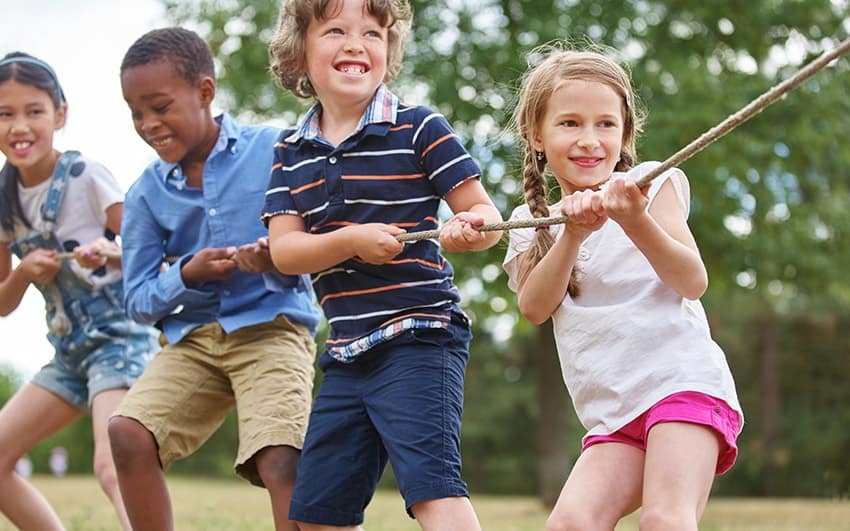 Four children playing tug with a rope