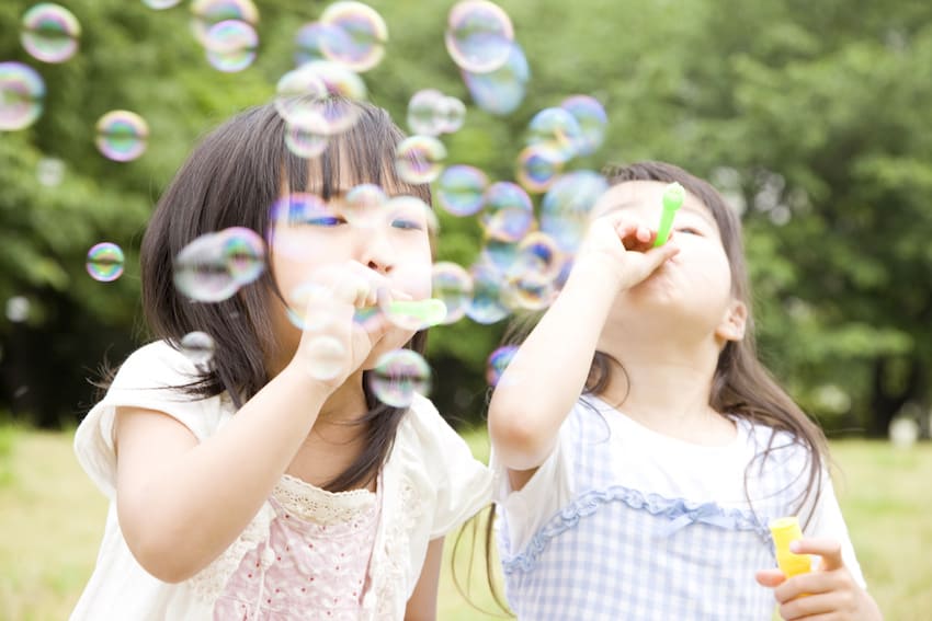 two young children blowing bubbles