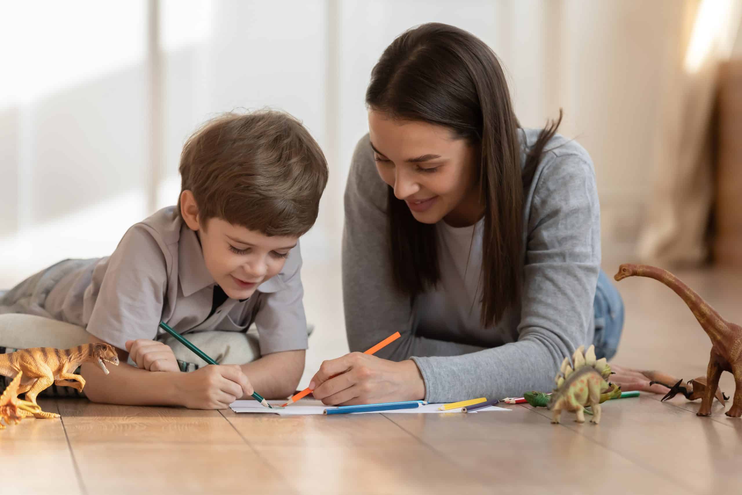 Nanny and boy coloring at the table