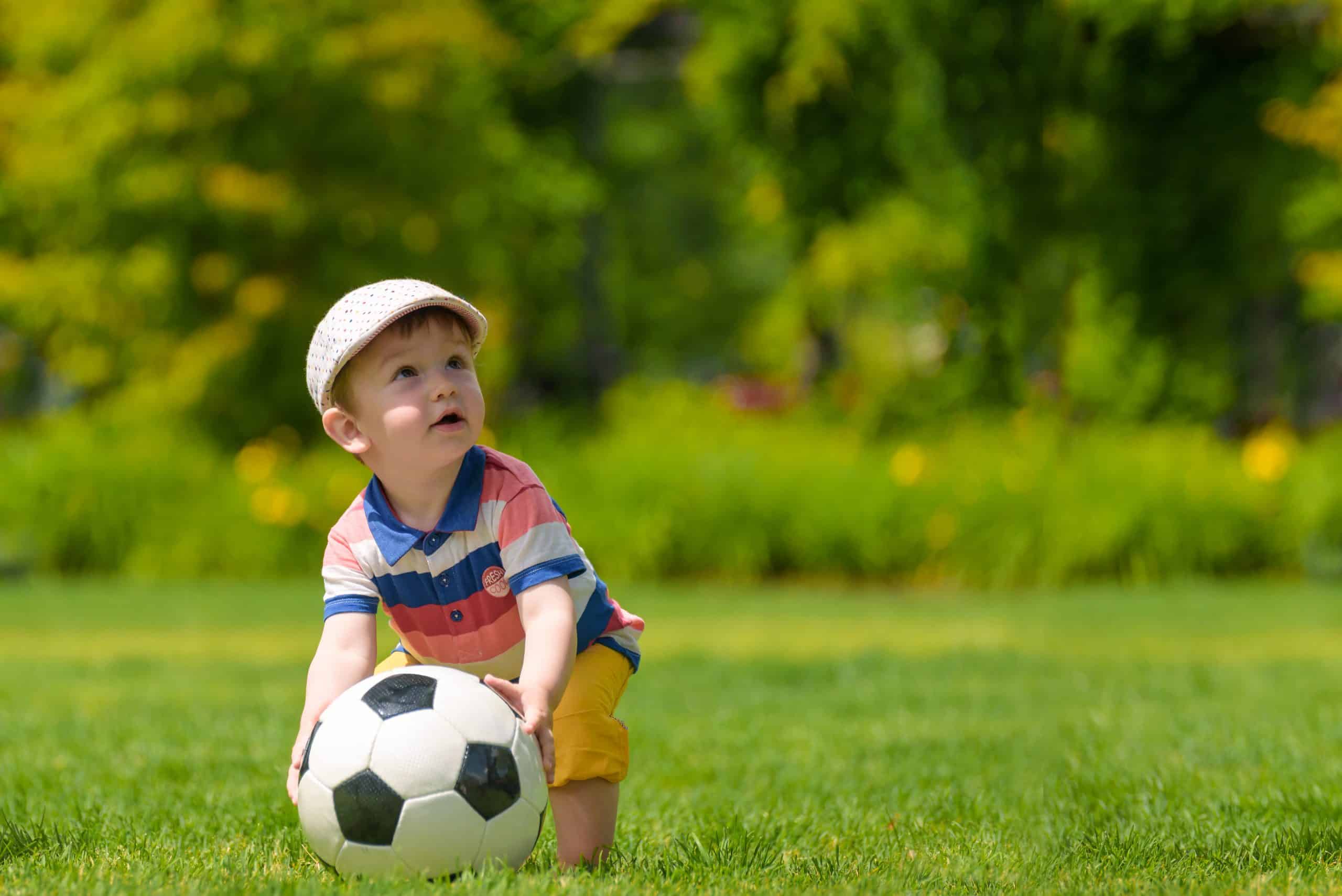 Boy holding a soccer ball outside