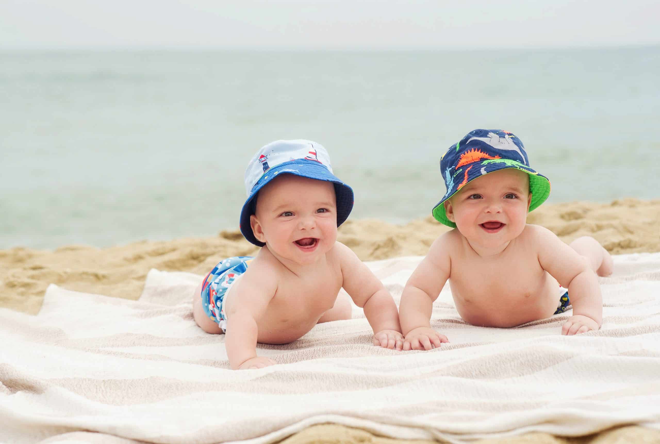 Twins rest on the beach on towel