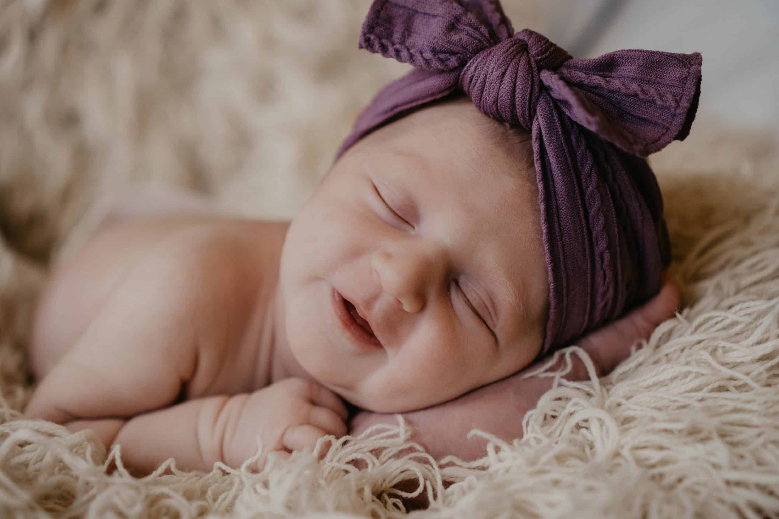 Newborn with a purple bow on her head – job Newborn with a purple bow on her head