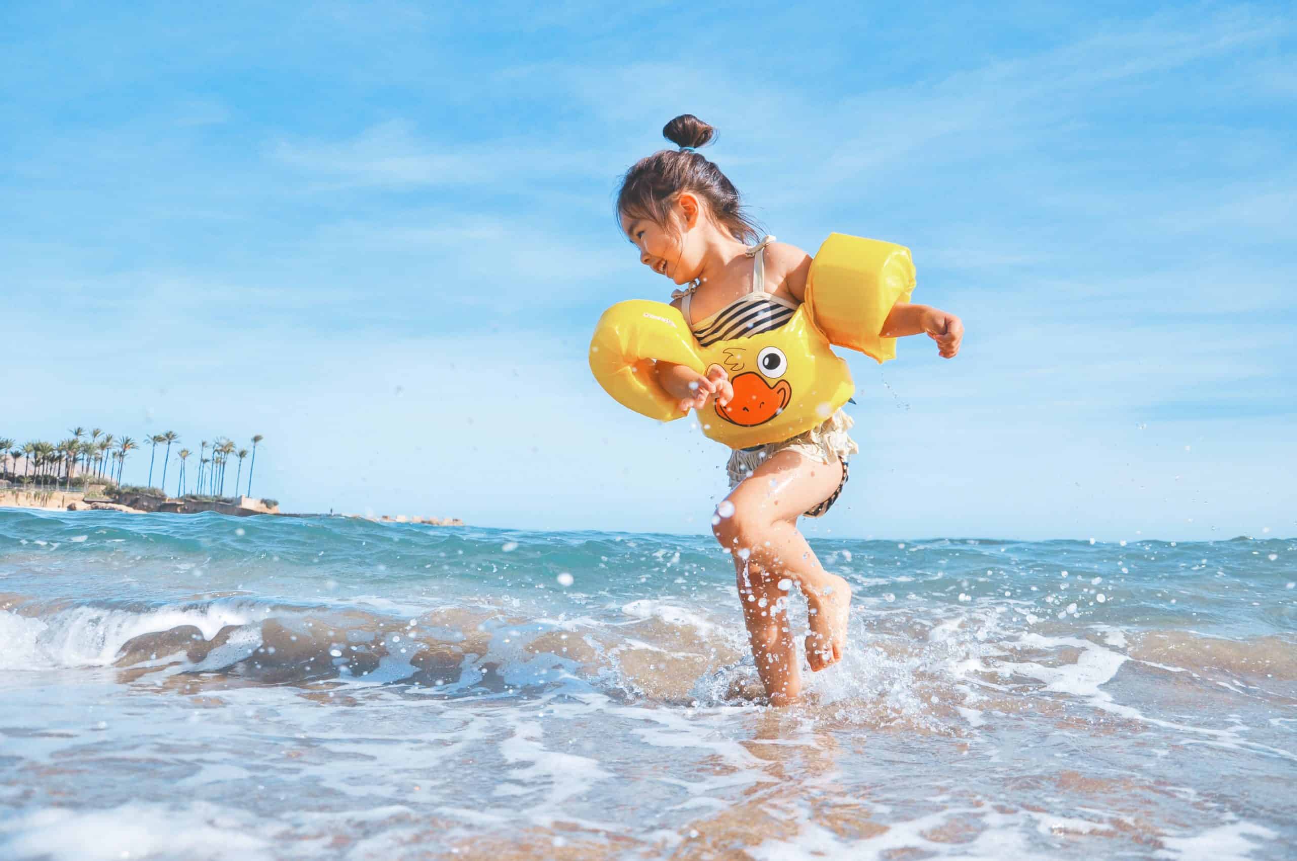 A girl wearing a ducky float at the ocean – job A girl wearing a ducky float at the ocean