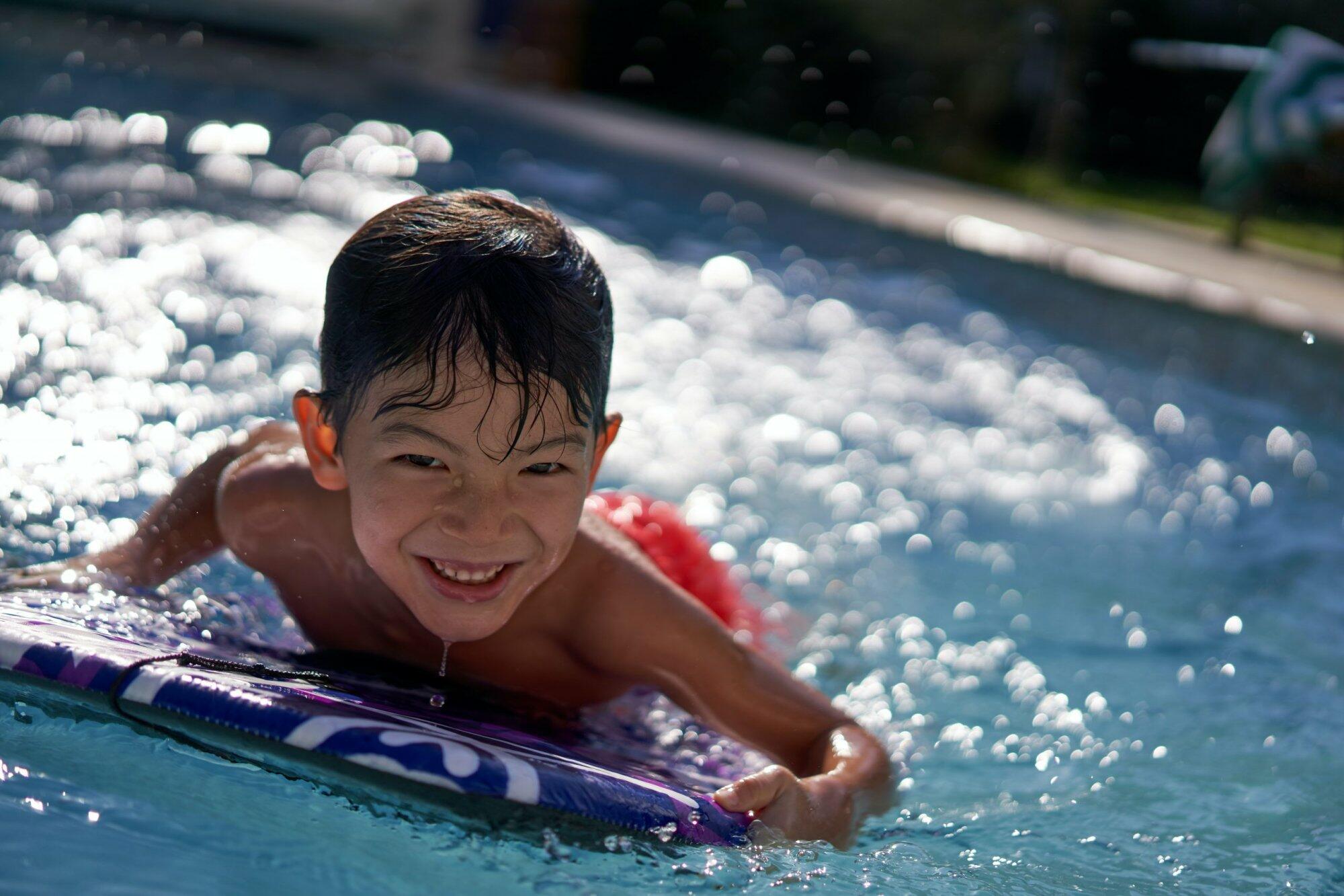 Little boy on a boogie board in the pool – job Little boy on a boogie board in the pool