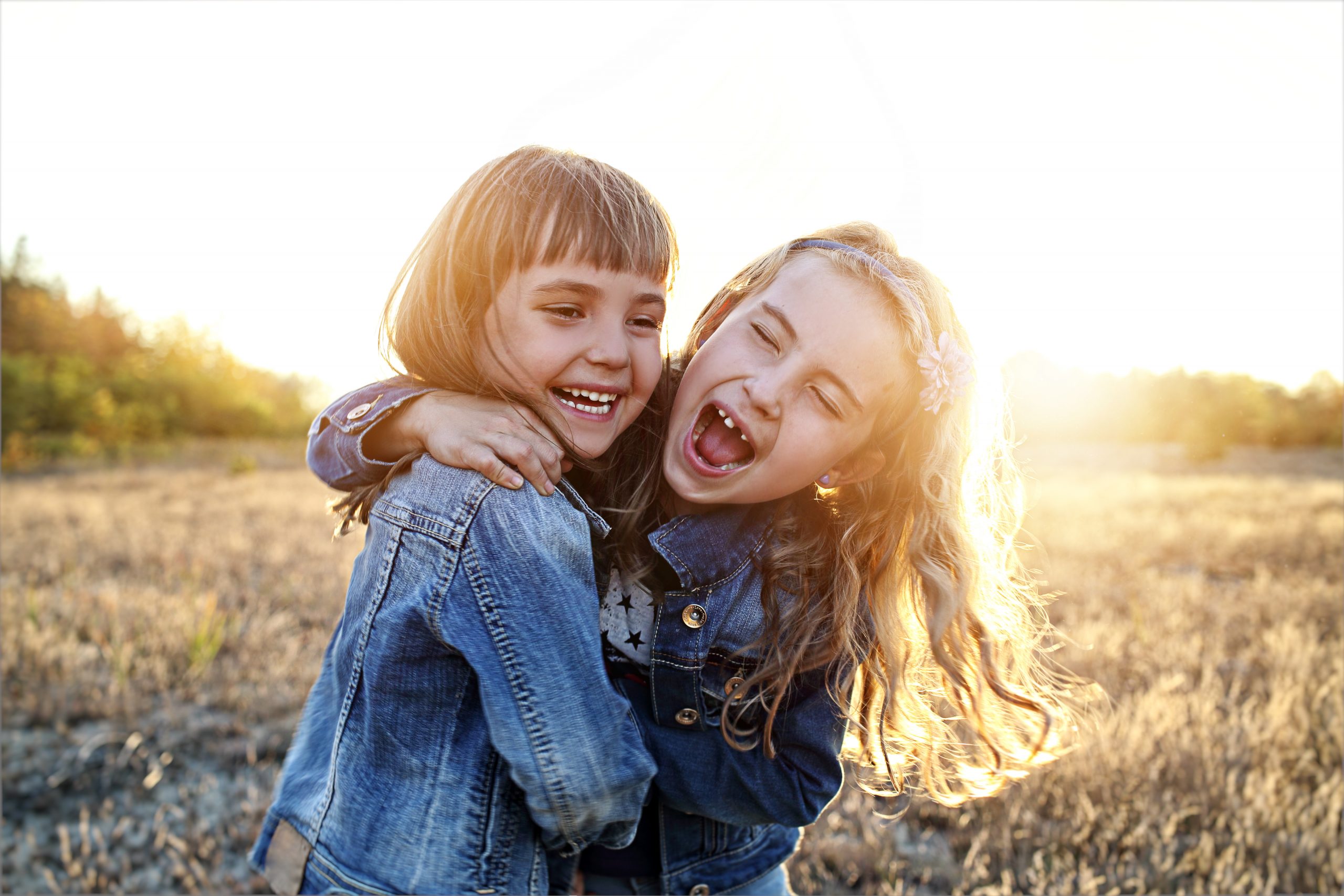 Two,Young,Girls,Have,Fun,Outside, -job two young girls laughing and hugging in the sunshine