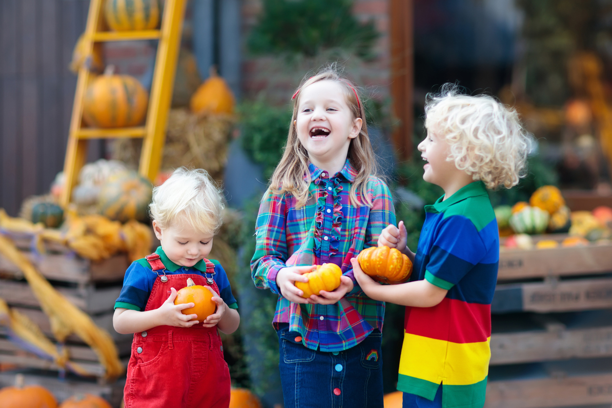 Kids having fun at pumpkin patch -job Kids having fun at pumpkin patch wearing brightly colored clothes