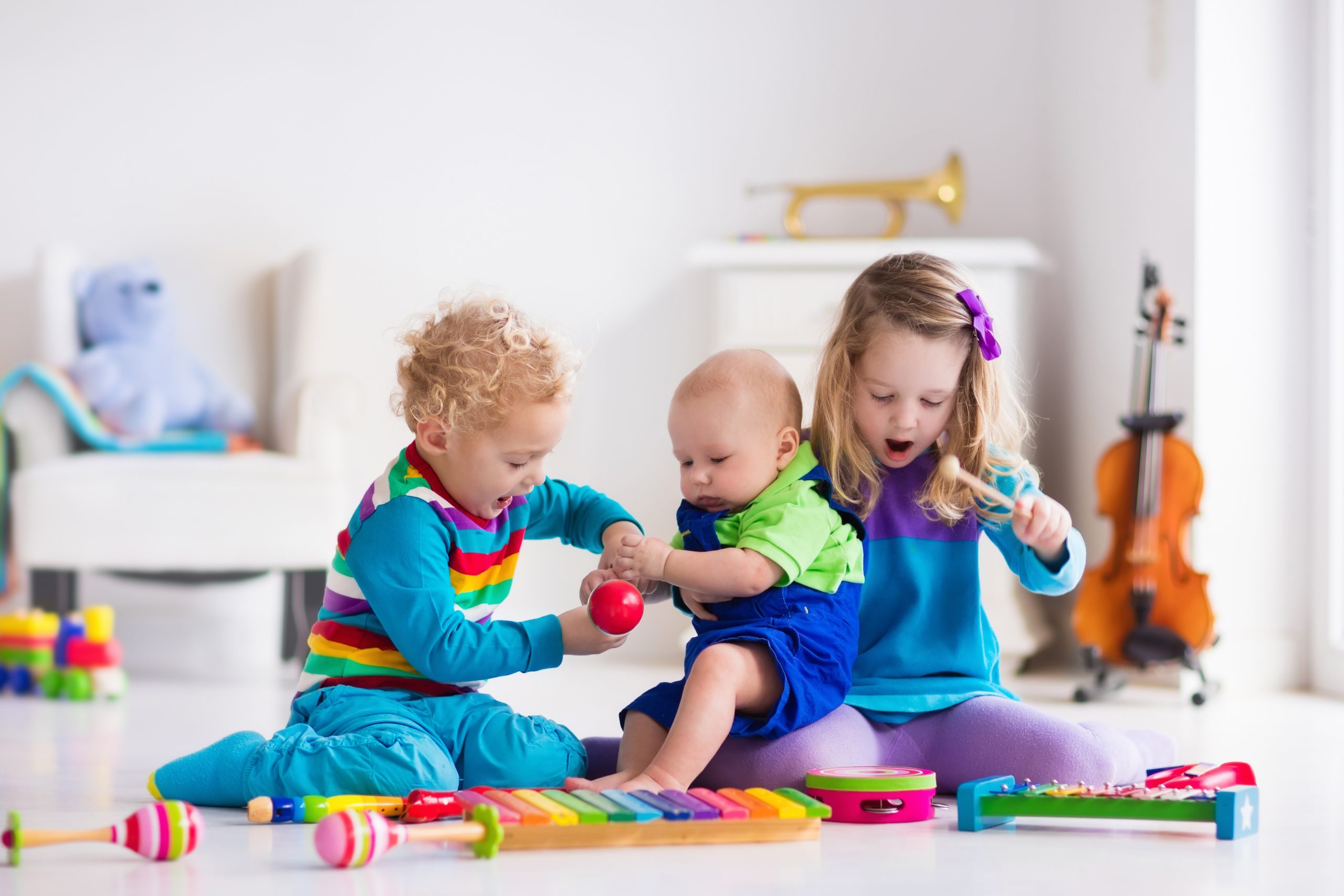 Children,With,Music,Instruments -job Three young kids wearing colorful clothes playing with musical instruments